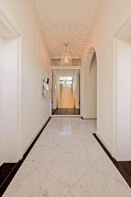 a hallway with white walls and a chandelier at Bohemian Residence in Maastricht