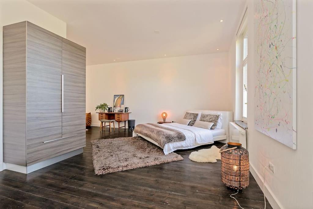 a bedroom with a bed and a large cabinet at Bohemian Residence in Maastricht