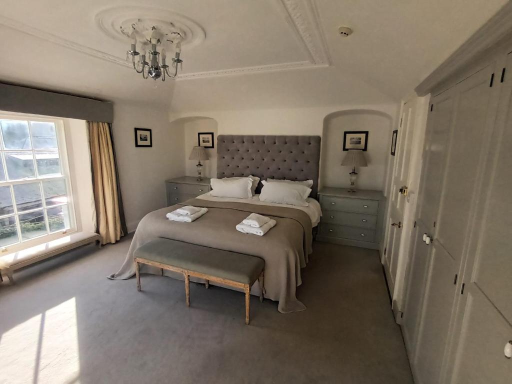 sypialnia z dużym łóżkiem i żyrandolem w obiekcie The Mount w mieście Bideford