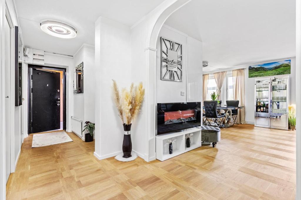 a living room with a television and a vase of flowers at Fräscht och mysigt enkelrum med eget badrum och dusch in Stockholm