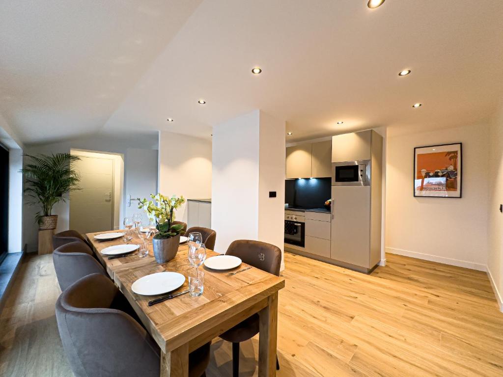 a dining room with a wooden table and chairs at Mr.Bernard Vakantie Appartementen in De Panne