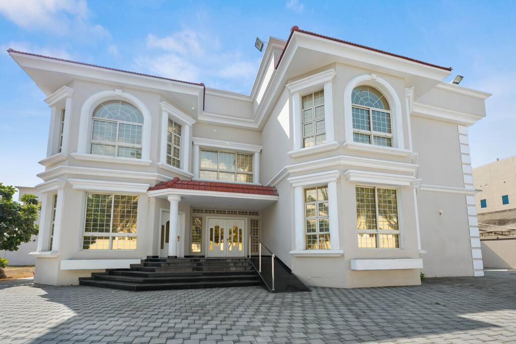 una gran casa blanca con muchas ventanas en Luxury Emirates Private Villa in Dubai Jumeirah, en Dubái