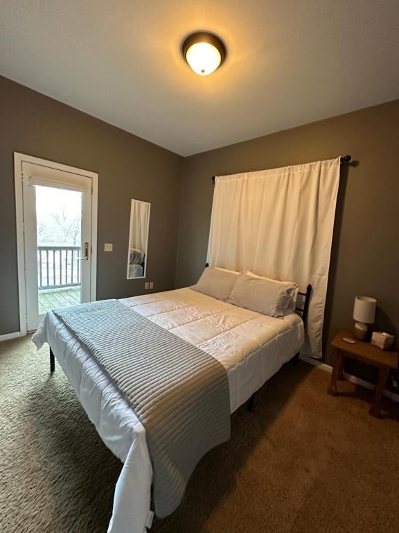 - une chambre avec un grand lit et une fenêtre dans l'établissement Driftwood Cottage with Hot Tub on Lake Cumberland, à Russell Springs
