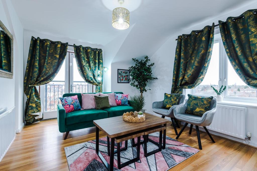 a living room with a green couch and two chairs at Charming 2Bed Retreat in Historic Coventry in Coventry