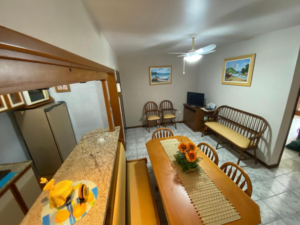 a living room with a table and chairs at Acesso a tudo no centro e 6min a pé do mar in Capão da Canoa