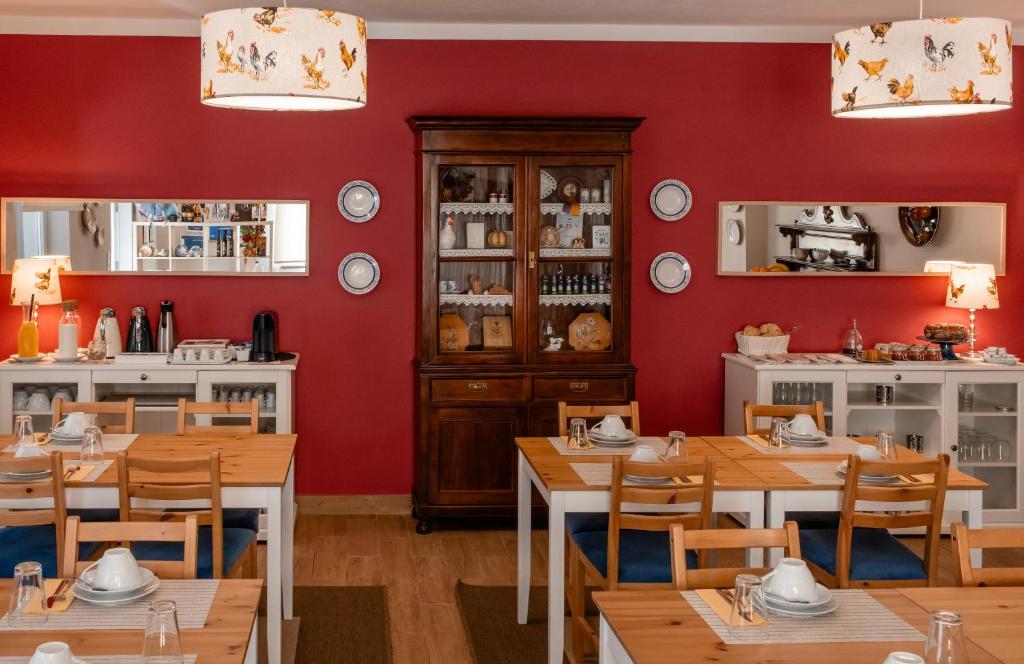 a restaurant with red walls and wooden tables and chairs at Casal da Viúva in Armamar