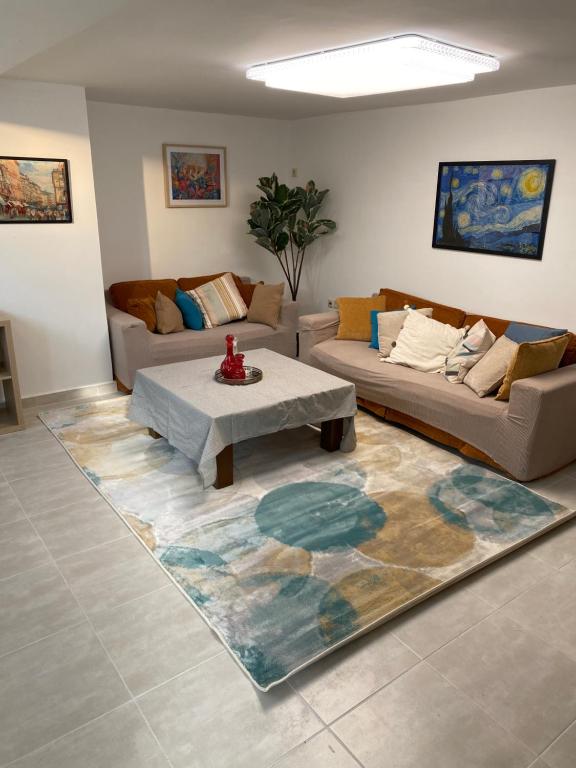 a living room with two couches and a rug at Enna House 2 in Athens
