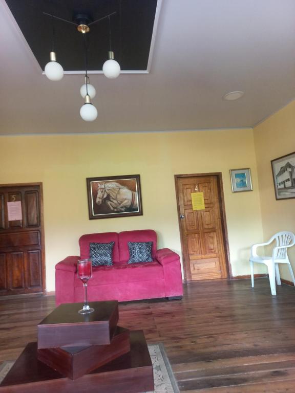 uma sala de estar com um sofá rosa e uma mesa em Casa de Albert em Quito