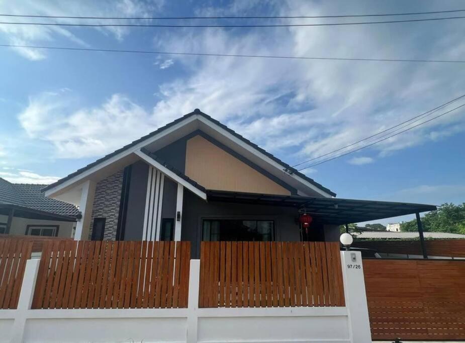 a house with a fence in front of it at บ้านม่วนใจ๋สันกำแพง in San Kamphaeng