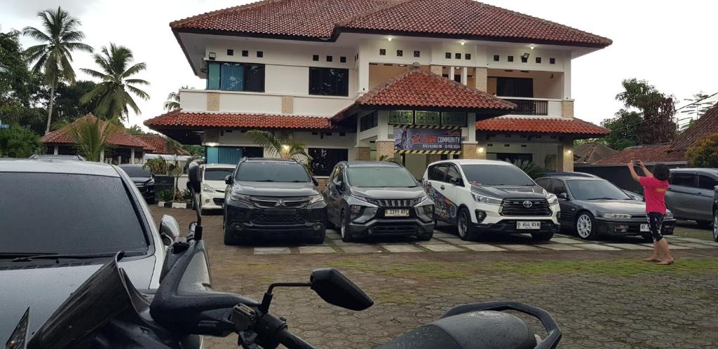 eine Gruppe von Autos, die vor einem Gebäude geparkt sind in der Unterkunft Hotel pondok putri in Batukaras