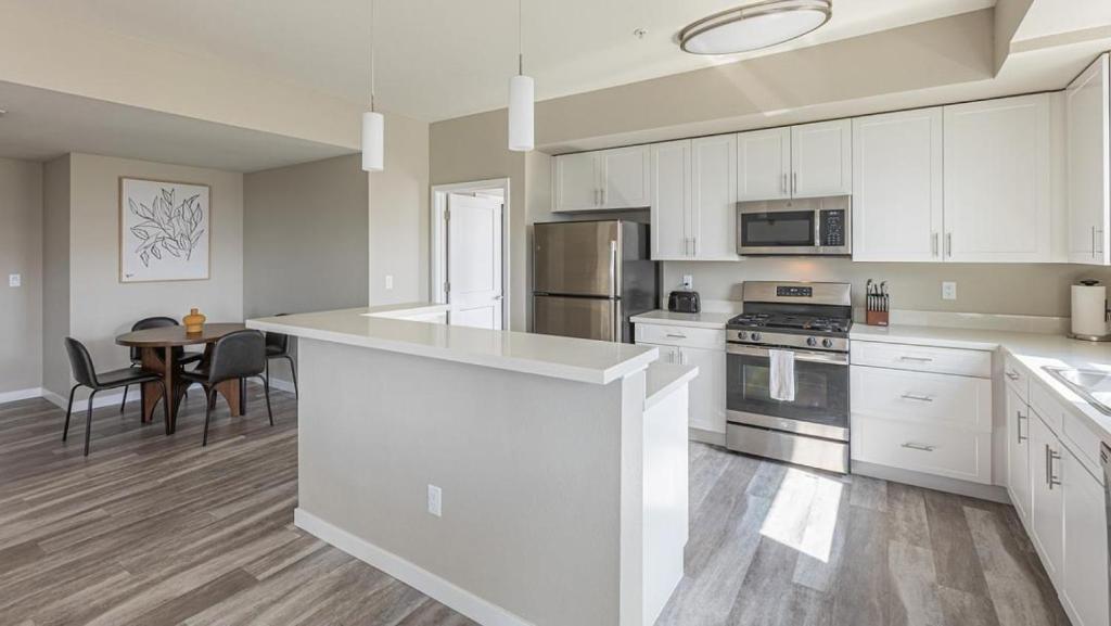 a large kitchen with white cabinets and a table at Landing Modern Apartment with Amazing Amenities (ID7328X47) in Sparks