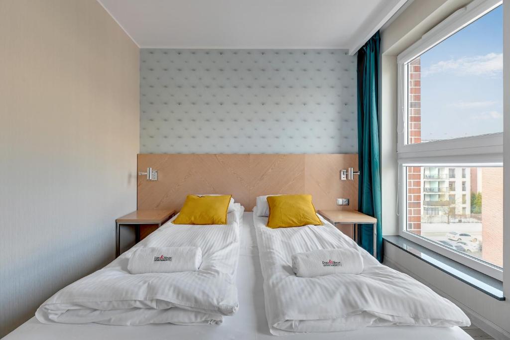 two beds in a small room with a window at Dom & House - Apartments Angielska Grobla - Self Check-in in Gdańsk