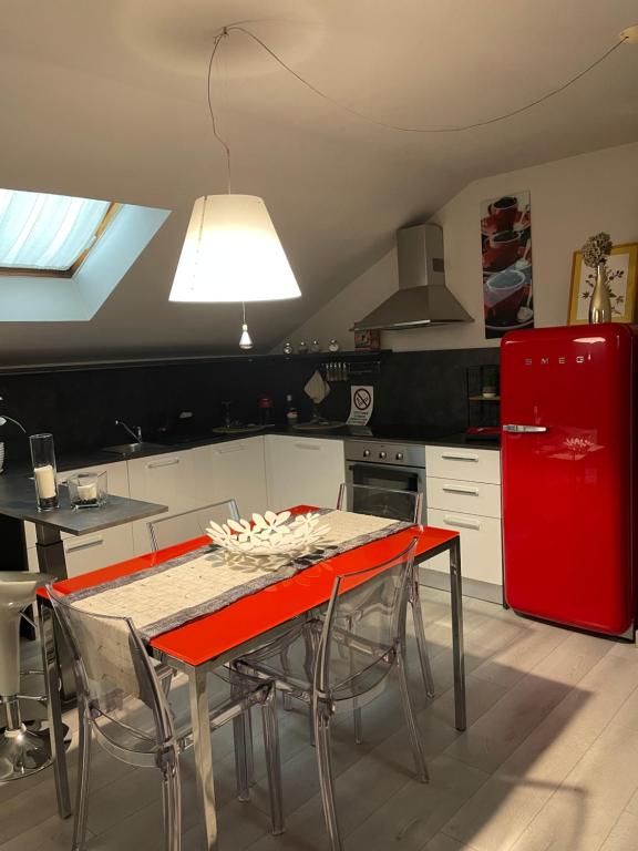 una cucina con tavolo e frigorifero rosso di Confortevole appartamento in zona centrale a Torino