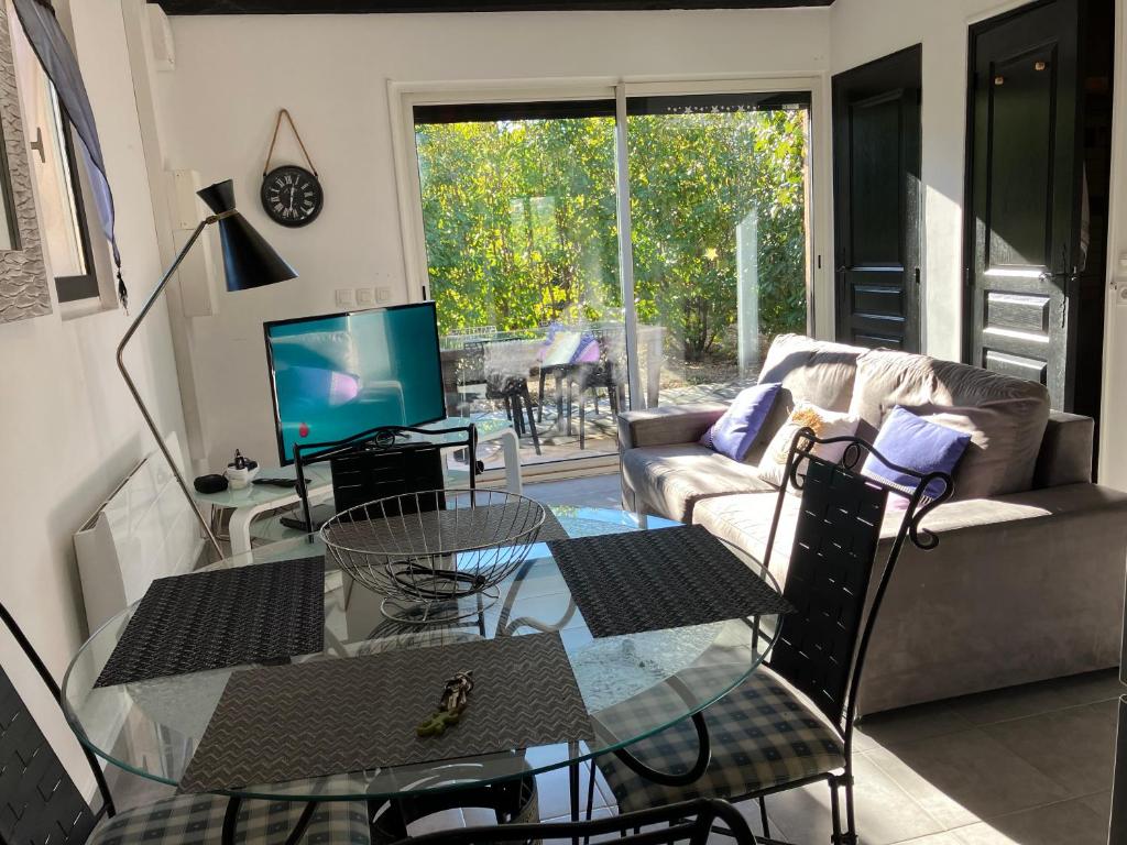 ein Wohnzimmer mit einem Glastisch und einem Sofa in der Unterkunft Beau duplex climatisé dans une villa calme. in Peymeinade