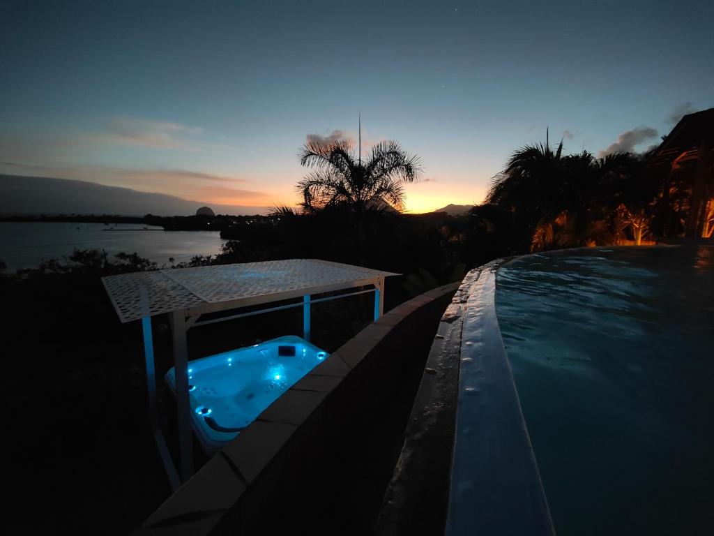 una piscina con cenador junto al agua en Villa Nadia - Prestige et Confort Absolu avec Vue Imprenable sur la Mer, en Le Diamant