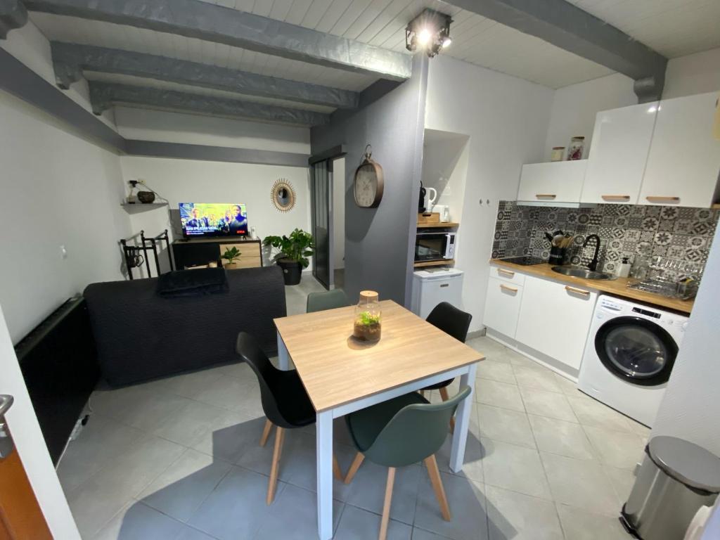 uma cozinha e sala de estar com uma mesa de madeira e cadeiras em Chez William et Elisa em Jonzac