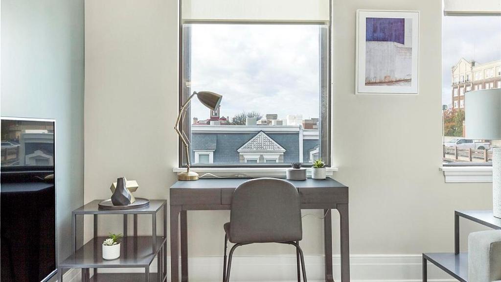 einen Schreibtisch mit Stuhl in einem Zimmer mit Fenster in der Unterkunft Landing Modern Apartment with Amazing Amenities (ID1239X428) in Richmond