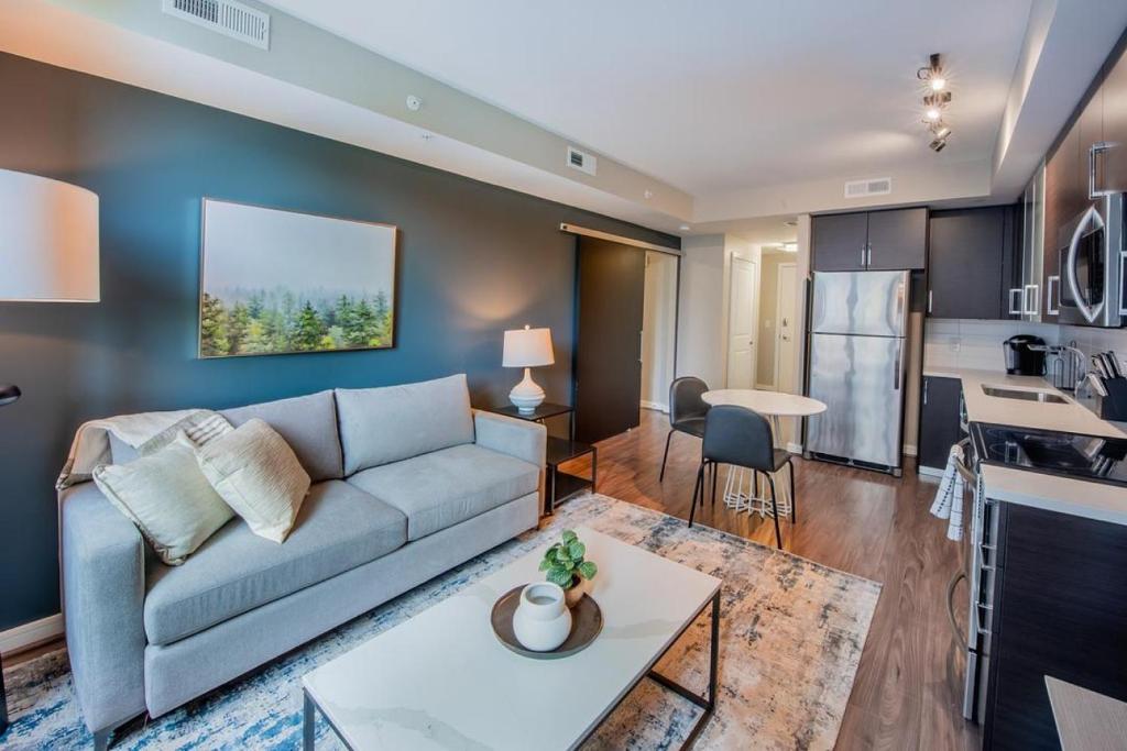 a living room with a couch and a kitchen at Landing Modern Apartment with Amazing Amenities (ID1957X30) in Arlington