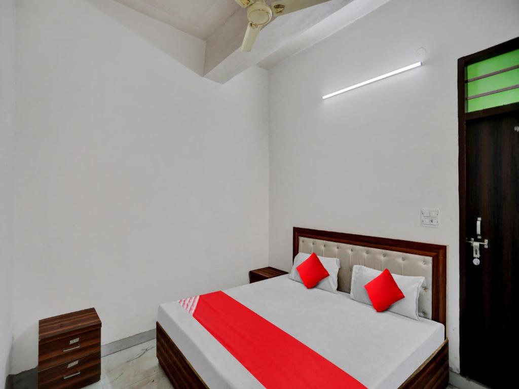 a bedroom with a bed with red pillows at OYO Flagship Hotel Royal Choice in Rohtak