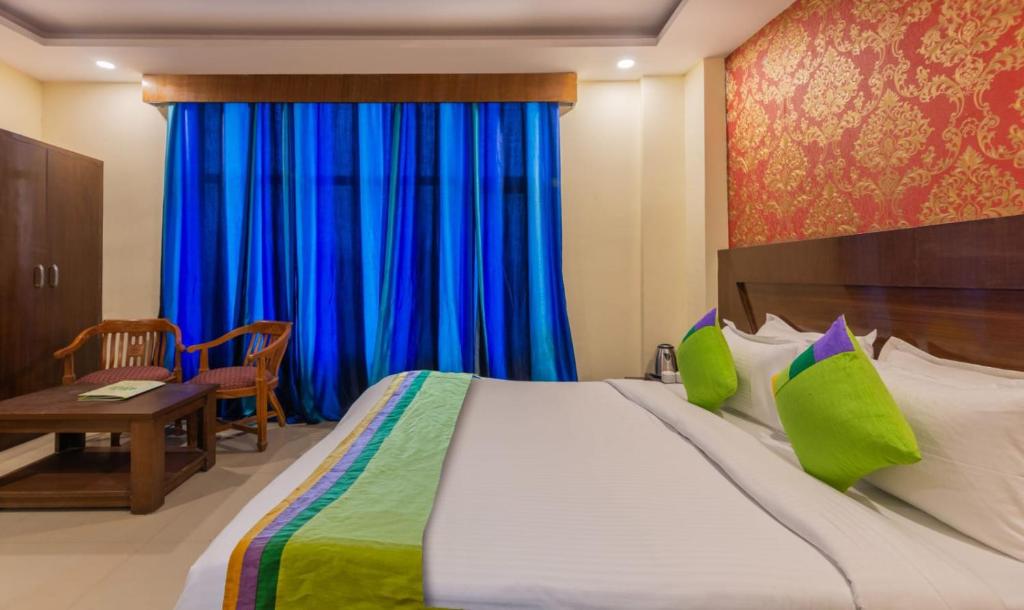 1 dormitorio con 1 cama grande y cortinas azules en HOTEL GREEN VIEW PALACE, en Ghaziabad