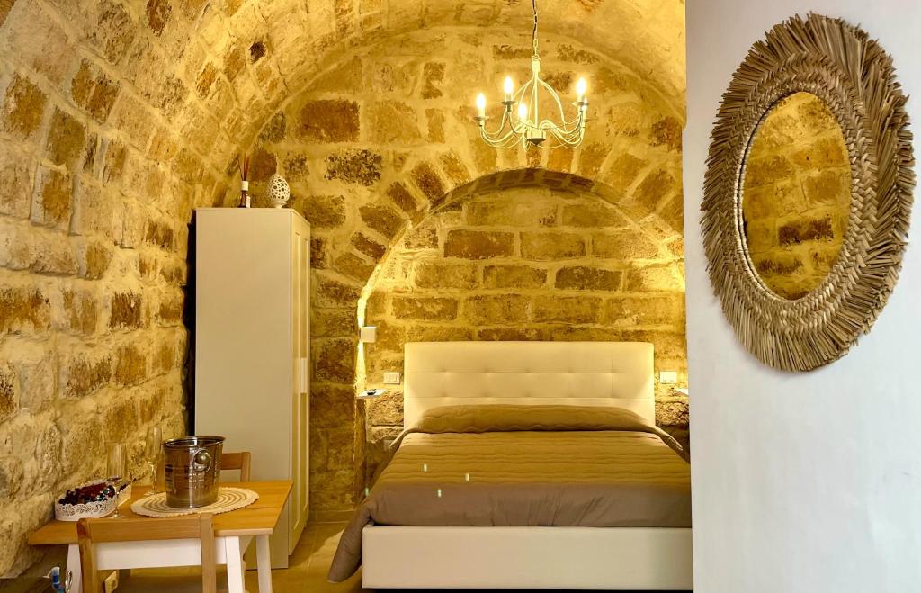sypialnia z łóżkiem w ceglanej ścianie w obiekcie Casa Vacanze A un Passo dal Volo w mieście Bari