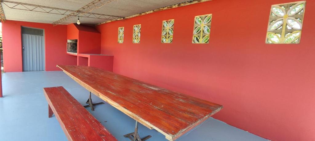 a wooden bench in a room with a red wall at Departamento Bienestar Termas in Federación