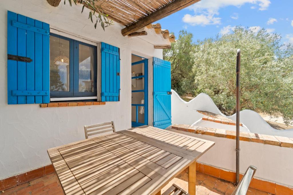 un patio con un tavolo e persiane blu di suite paradiso a Quartu SantʼElena