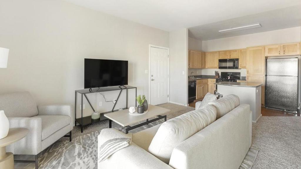uma sala de estar com mobiliário branco e uma cozinha em Landing Modern Apartment with Amazing Amenities (ID1256X519) em Las Vegas