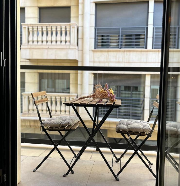 a table and two chairs in front of a window at Apartamento Boutique - Palm City Centro in Elche
