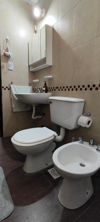 a bathroom with a toilet and a sink in it at Departamento Bienestar Termas in Federación
