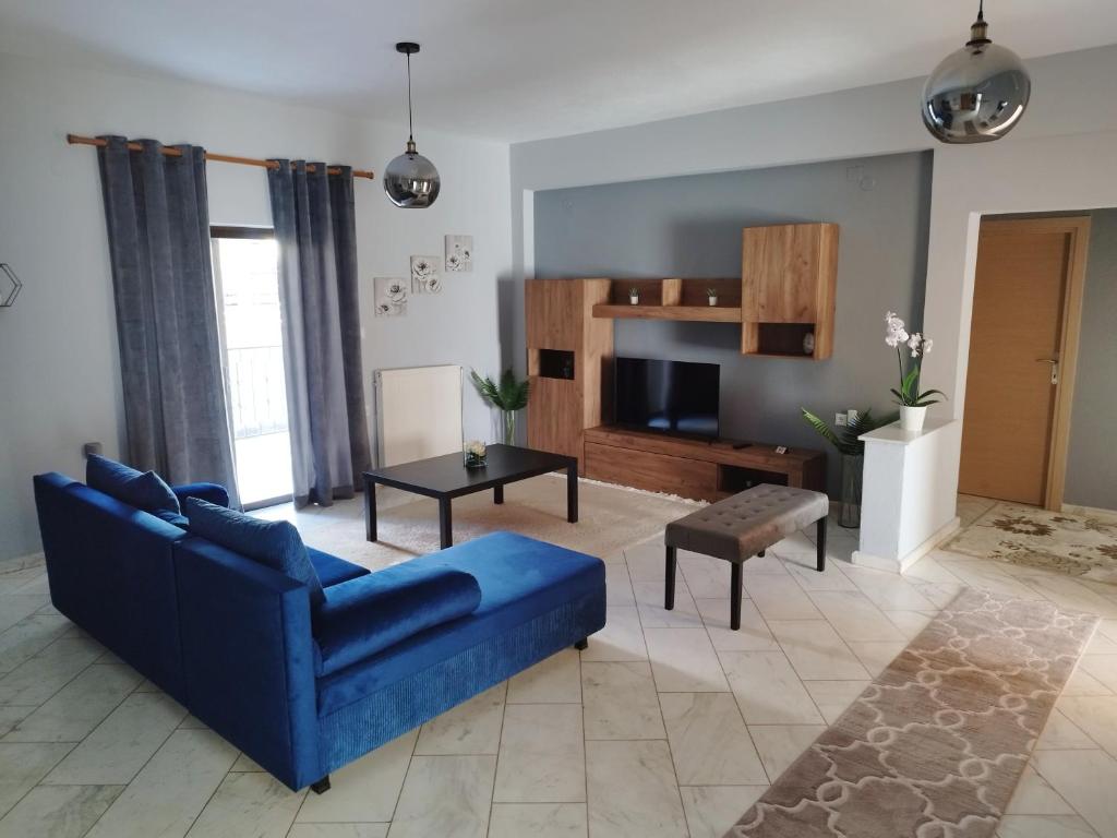 ein Wohnzimmer mit einem blauen Sofa und einem TV in der Unterkunft Meteora House with a view in Kalambaka