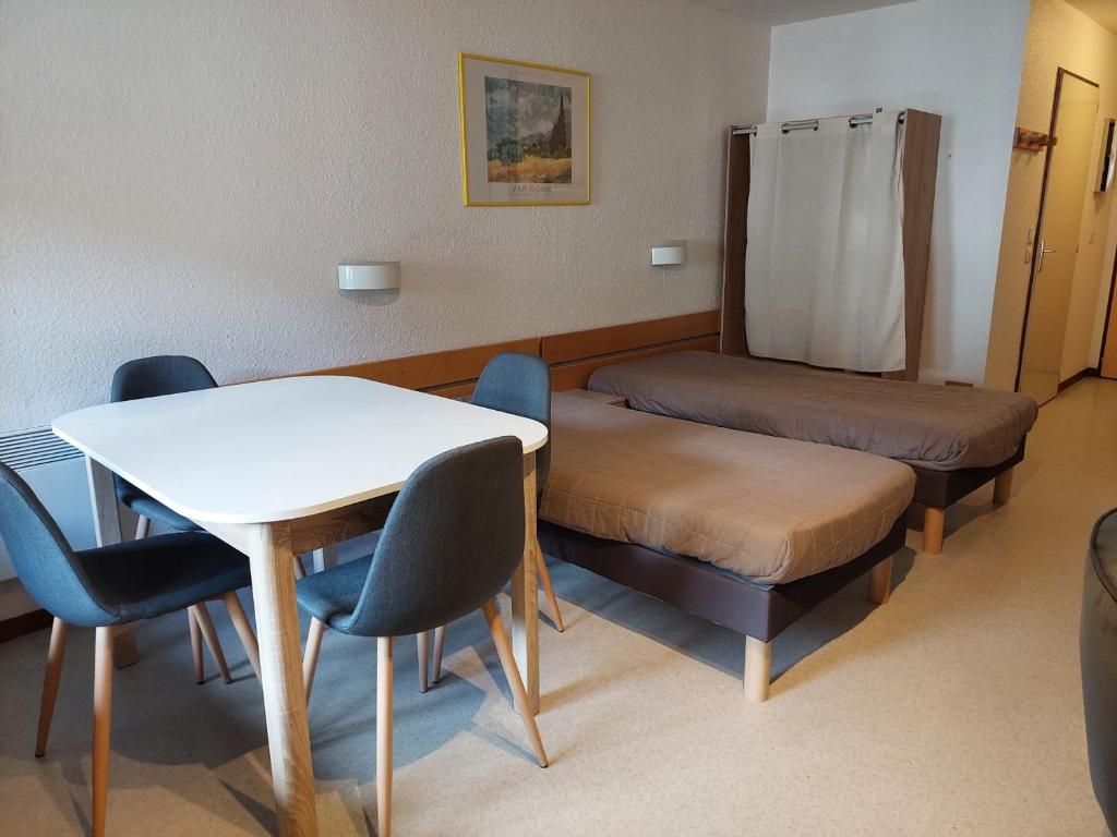 une chambre avec un lit, une table et des chaises dans l'établissement Charmant studio avec balcon et parking, centre et thermes à 500m - FR-1-512-96, à Brides-les-Bains