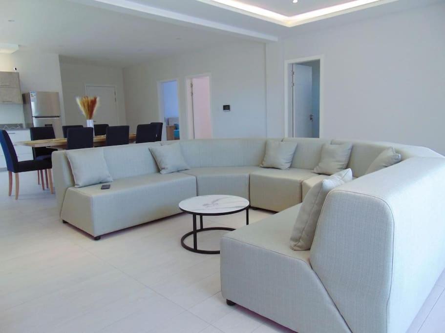 ein Wohnzimmer mit einem weißen Sofa und einem Tisch in der Unterkunft Spacious 3-Bedroom Apartment near Pereybere Beach in Pereybere