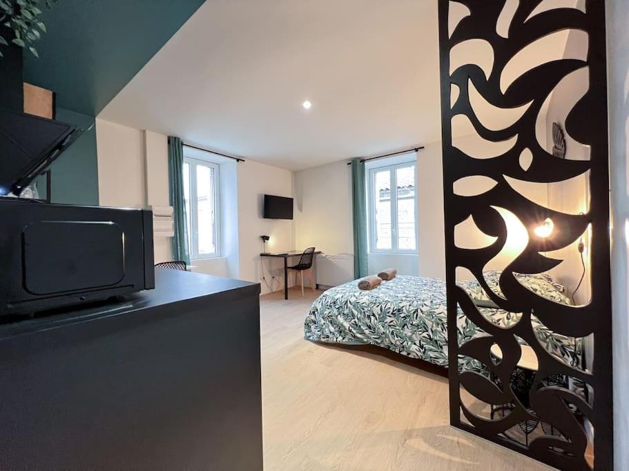 ein Schlafzimmer mit einem Bett und einem Fernseher in einem Zimmer in der Unterkunft LA FEUILLERAIE N2-Standingappart-Wifi-Proche ville in Fontenay-le-Comte