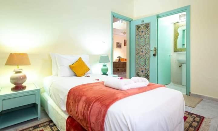 - une chambre avec deux lits et une table avec une lampe dans l'établissement Hôtel Restaurant Dar Al Madina, à Tinghir
