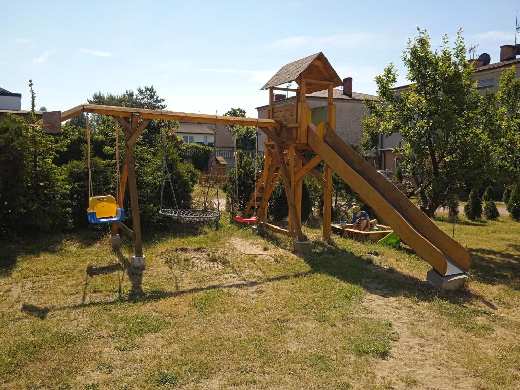 einen Spielplatz mit Rutsche im Hof in der Unterkunft NOCLEGI KAMEX domek 2-osobowy in Olsztyn