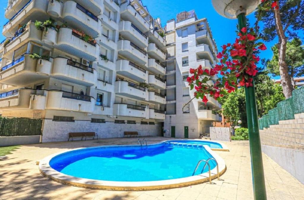 ein Apartment mit einem Pool vor einem Gebäude in der Unterkunft Cancún Portaventura Familidays in Salou