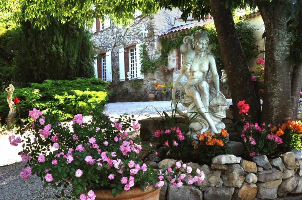 una estatua de una mujer en un jardín con flores en Le BASTIDON de CHANTE PIERRE, en Cuers