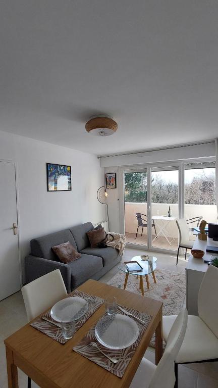 un salon avec un canapé et une table dans l'établissement Les 3 mouettes à Cabourg - côte normande, à Cabourg