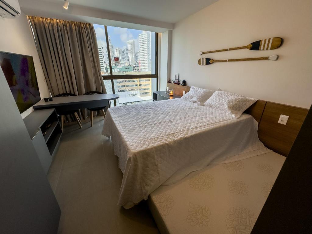 1 dormitorio con cama, escritorio y ventana en Flat em Boa Viagem Rooftop 470 Conforto e Localização privilegiada, en Recife