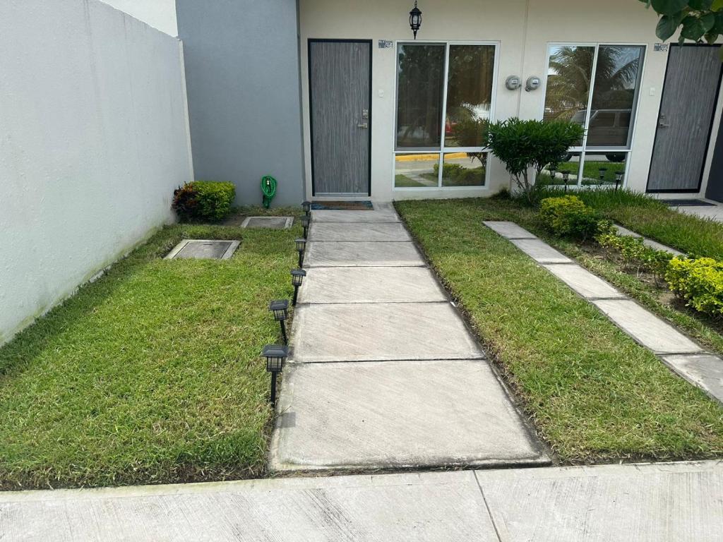 a sidewalk in front of a house with a door at Porteño Abode in Veracruz