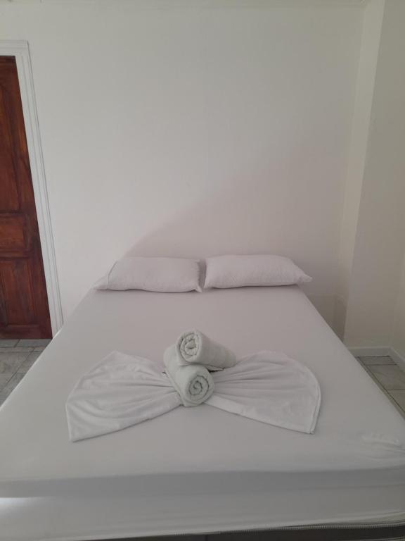 Una cama blanca con un arco encima. en Au paradis des Lapas, en Cabuya