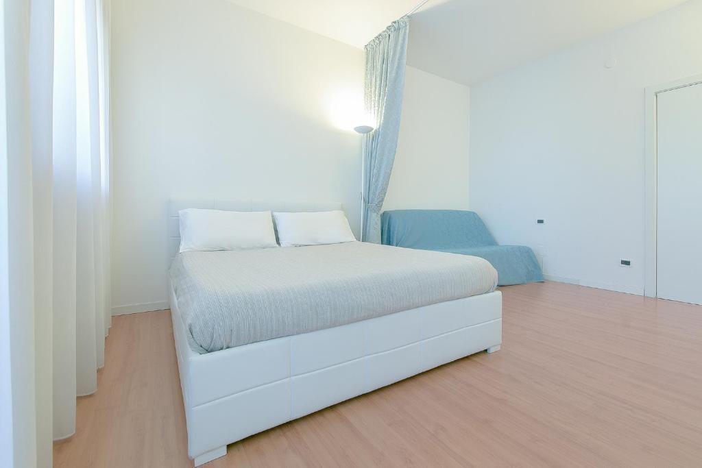 ein weißes Schlafzimmer mit einem weißen Bett in einem Zimmer in der Unterkunft QUEEN HOME GEMMA in Mestre