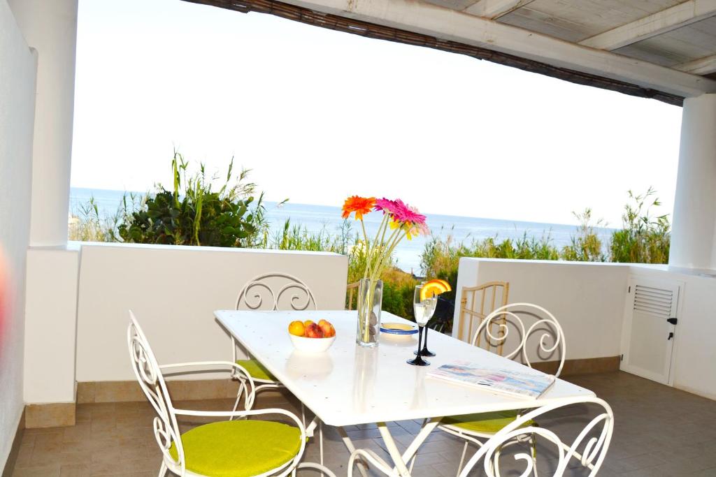 a white table and chairs on a balcony with the ocean at Villa Ginestra sulla spiaggia di Stromboli in Stromboli