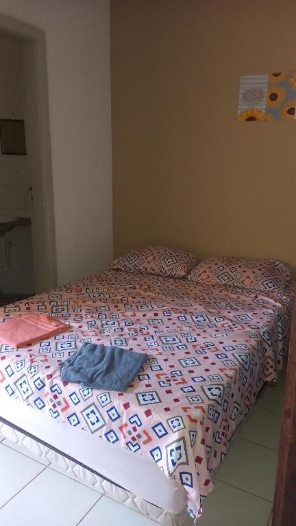 1 cama con edredón en un dormitorio en Quarto para temporada na praia do corsário, en Salvador
