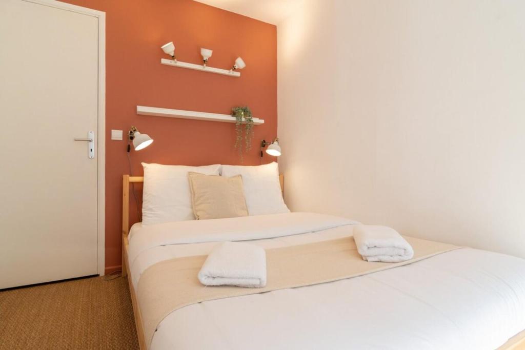 2 camas en una habitación con paredes de color naranja en Vieux Lille -Nice studio neat and fully equipped !, en Lille