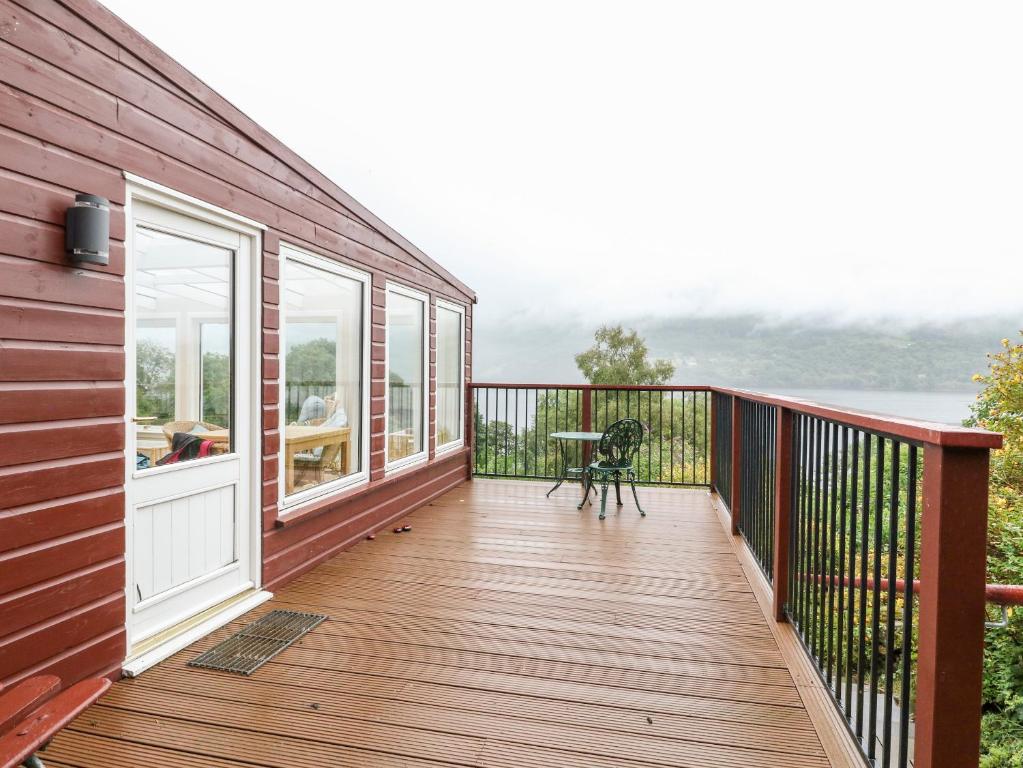 a deck with a view of the water at Waterfall Cottage in Aberfeldy