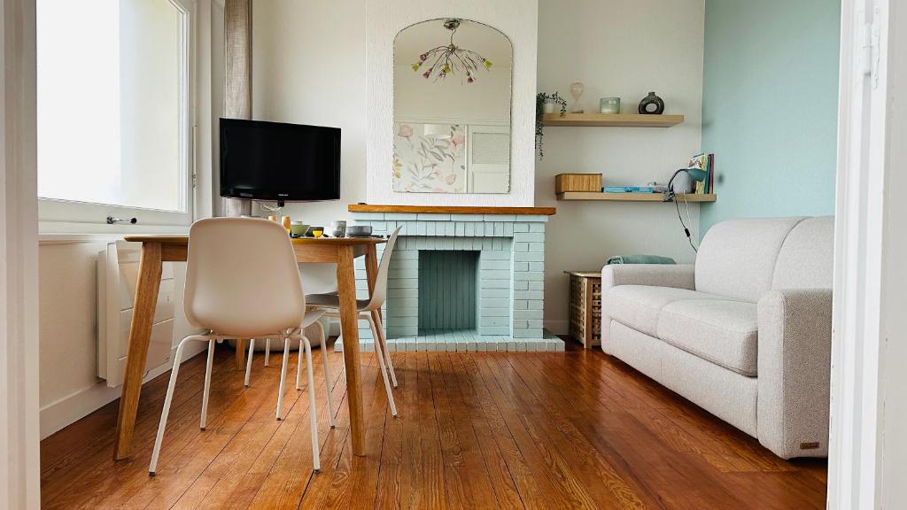 ein Wohnzimmer mit Tisch und Couch in der Unterkunft Appartement la capitainerie in Cayeux-sur-Mer