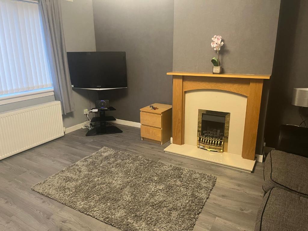 sala de estar con chimenea y TV en Lanarkshire entire house sleeps 6, contractors, trade stays, en Kilsyth