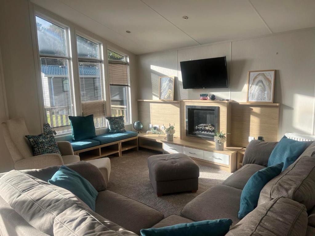 un soggiorno con divano e TV di Pinehurst, 65 Golf View Lodge a Jedburgh